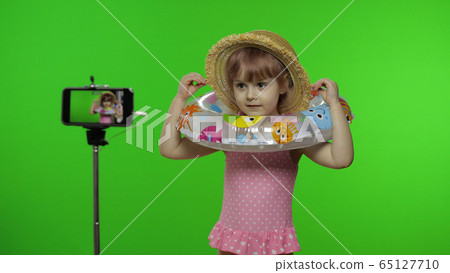 Girl child makes selfie vlog, blogging, video call on mobile phone. Vacation sea 65127710