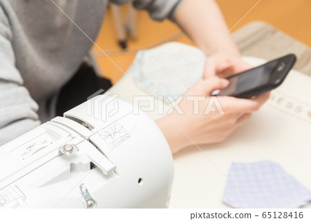 Woman making a handmade mask Woman making a handmade mask 65128416