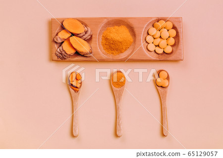 Turmeric in different conditions: fresh, dry root, pills, powder and cut plant. 65129057