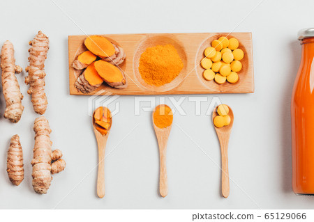 Turmeric in different conditions: fresh, dry root, pills, powder and cut plant. Turmeric in different conditions: fresh, dry root, pills, powder and cut plant. 65129066