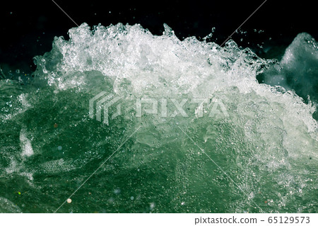 Splashes of water from the waves in the sea 65129573
