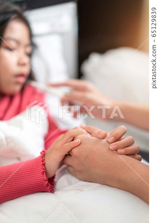 Asian mother touch hand young daughter for Asian mother touch hand young daughter for 65129839