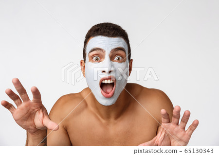 Photo of shirtless african american man smiling and applying face cream isolated over white background Photo of shirtless african american man smiling and applying face cream isolated over white background 65130343