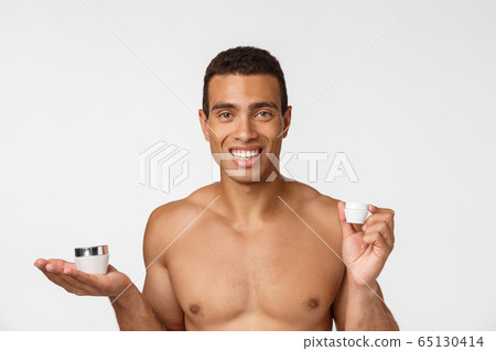 Photo of shirtless african american man smiling and holding cream isolated over white background Photo of shirtless african american man smiling and holding cream isolated over white background 65130414
