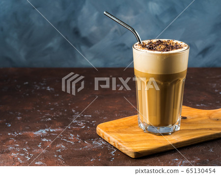 Frappe coffee in tall glass on blue and brown 65130454