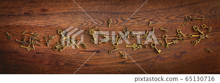 Magical bronze keys on a wooden oak surface Magical bronze keys on a wooden oak surface 65130716