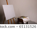Easel and blank canvas. Palette with paints and brushes. Squeeze out oil paints on a palette and pieces of canvas. Clean canvas and copy space. Oil painting. 65131526