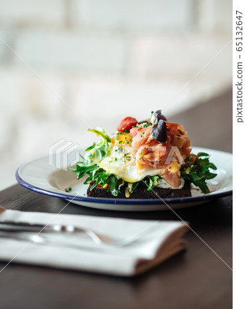 Breakfast rye toast with poached egg and salmon Breakfast rye toast with poached egg and salmon 65132647