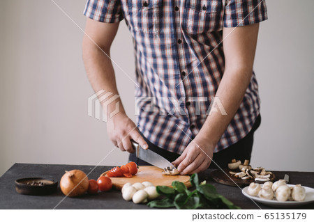 Closeup portrait of man cooking healthy dinner Closeup portrait of man cooking healthy dinner 65135179