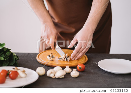 Closeup portrait of man cooking healthy dinner Closeup portrait of man cooking healthy dinner 65135180