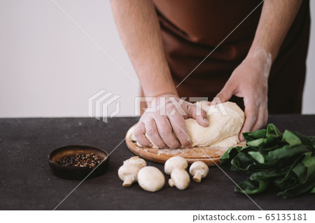 Chef baker hands kneading pizza dough, close up Chef baker hands kneading pizza dough, close up 65135181