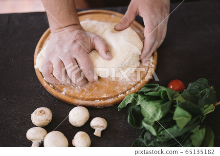 Chef baker hands kneading pizza dough, close up Chef baker hands kneading pizza dough, close up 65135182