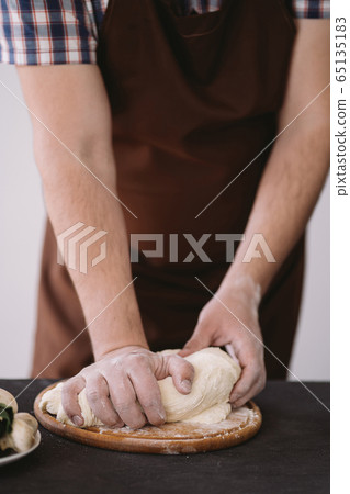 Chef baker hands kneading pizza dough, close up Chef baker hands kneading pizza dough, close up 65135183