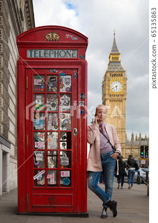 Woman talking on mobile phone, red telephone box and Big Ben. London, England Woman talking on mobile phone, red telephone box and Big Ben. London, England 65135863