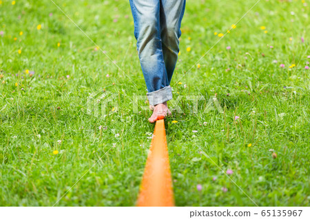 Slack line in the city park. 65135967
