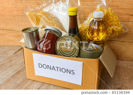 Donations box with canned food on wooden table 65136394