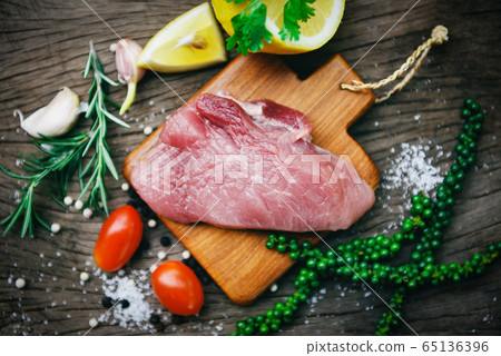 Raw pork meat on wooden cutting board on the 65136396