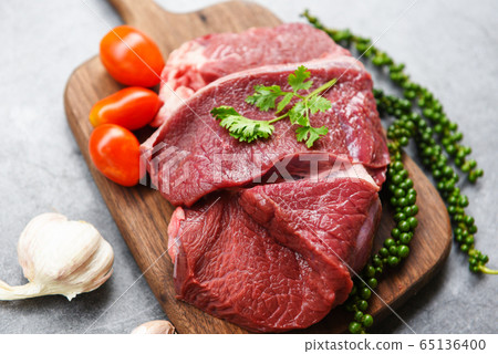 Raw beef meat on wooden cutting board on the Raw beef meat on wooden cutting board on the 65136400