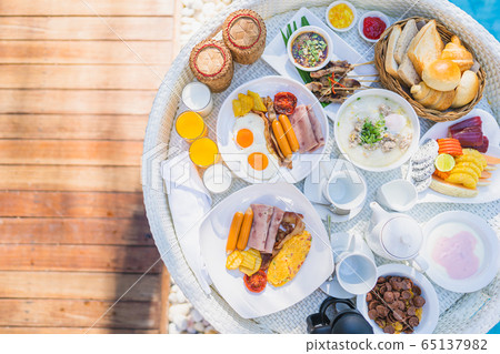 Floating breakfast set in tray with fried egg omelette sausage ham bread fruit milk juice coffee Floating breakfast set in tray with fried egg omelette sausage ham bread fruit milk juice coffee 65137982