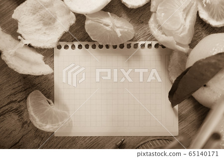 Empty notebook pages and tangerines 65140171