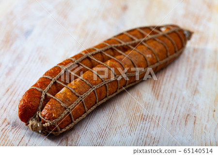 Sliced half-smoked sausages on wooden table Sliced half-smoked sausages on wooden table 65140514