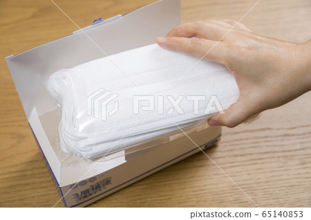 Female hand to take out the mask from the box and check Female hand to take out the mask from the box and check 65140853