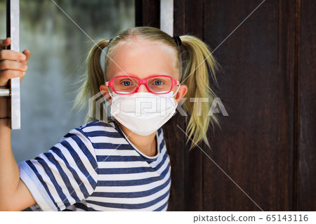 Child wearing face masks peeking out the door 65143116