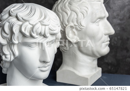 Group gypsum busts of ancient statues human heads for artists on a dark background. Plaster sculptures of antique people faces. Renaissance epoch style. Academic subject. Blank for creativity. Group gypsum busts of ancient statues human heads for artists on a dark background. Plaster sculptures of antique people faces. Renaissance epoch style. Academic subject. Blank for creativity. 65147821