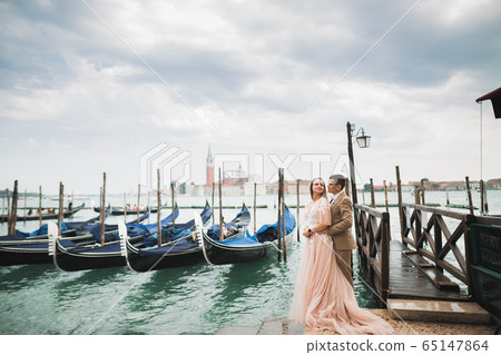 Wedding couple on the nature is hugging each other. Beautiful model girl in white dress. Man in suit.Venice, Italy 65147864