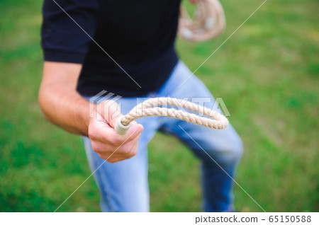 Outdoor games - guy playing ring toss in a park. Outdoor games - guy playing ring toss in a park. 65150588