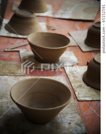 round soft brown color formed clay for ceramic utensils bowls under production process in a factory after throwing process leaving to dried out and prepare to burn in kiln. 65152591