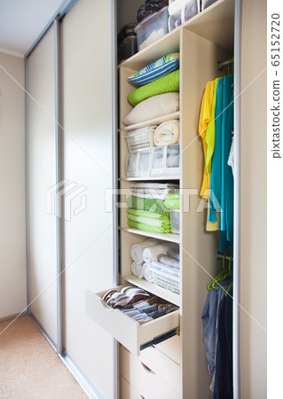 Wardrobe with women's and men's clothing. Drawers with underwear, bed linen, socks and shirts. Wardrobe with women's and men's clothing. Drawers with underwear, bed linen, socks and shirts. 65152720
