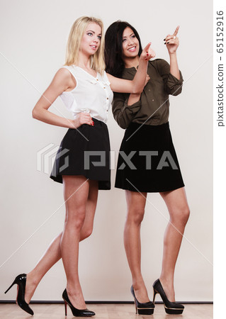 Two fashion women pointing wit finger Two fashion women pointing wit finger 65152916