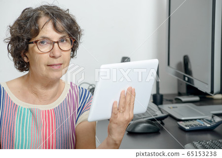 portrait of a mature woman with a digital tablet portrait of a mature woman with a digital tablet 65153238