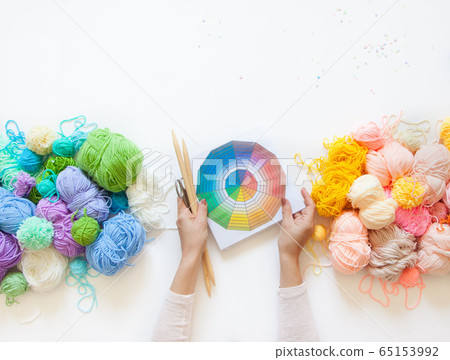 Yarn for knitted warm and cold shades. Female hands hold a color wheel. White background. Yarn for knitted warm and cold shades. Female hands hold a color wheel. White background. 65153992