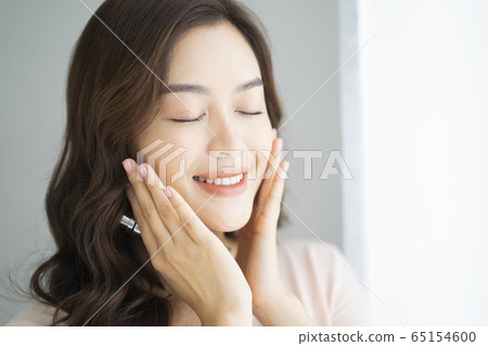 女人手裡拿著化妝品的肖像 女人手裡拿著化妝品的肖像 65154600