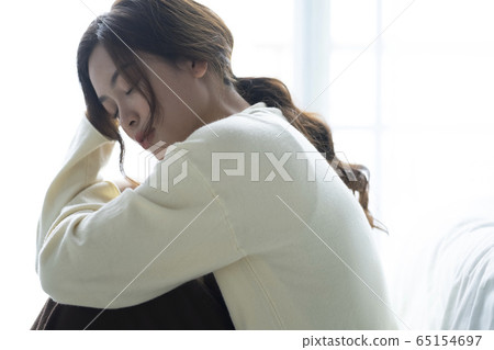 Depressed woman sitting on the floor 65154697
