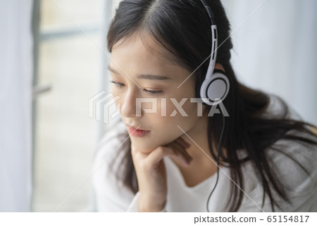 A young woman listening to music A young woman listening to music 65154817