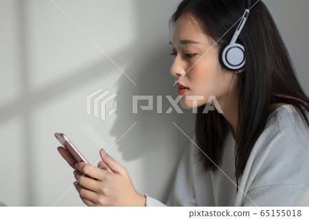 A woman who thinks while listening to music A woman who thinks while listening to music 65155018