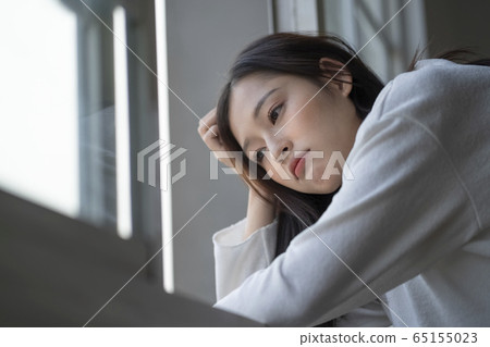 一個女人在窗台上擔心 65155023