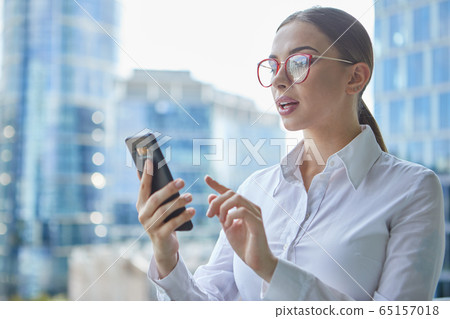 Female real estate agent talking by mobile phone 65157018