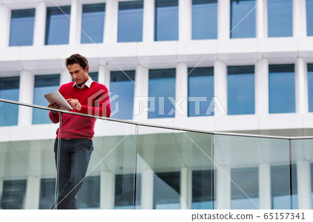 Young attractive businessman using digital tablet Young attractive businessman using digital tablet 65157341