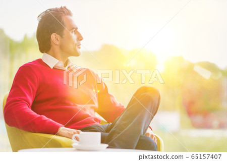 Young thoughtful businessman sitting while Young thoughtful businessman sitting while 65157407