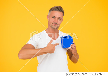 Romantic gift. Mature guy hold present box yellow 65157685