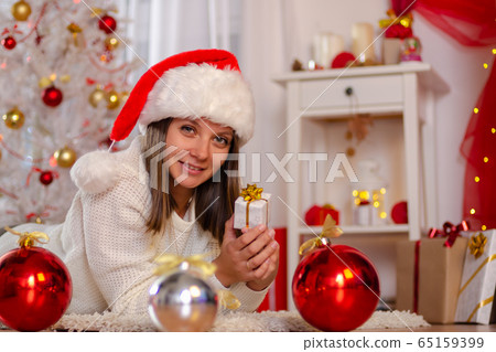 Happy girl in Christmas dress lies on the floor 65159399