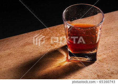 glass from whiskey on wooden table 65160743