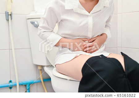 Cropped Woman sitting on toilet bowl and suffering from diarrheas 65161022
