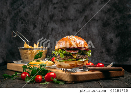Closeup burger, fries and tomatoes 65161716