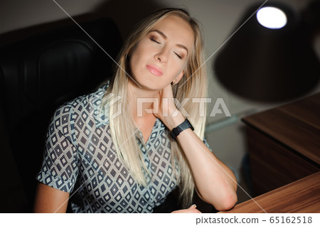 Portrait of stressed businesswoman sitting at office desk and thinking while working late Portrait of stressed businesswoman sitting at office desk and thinking while working late 65162518