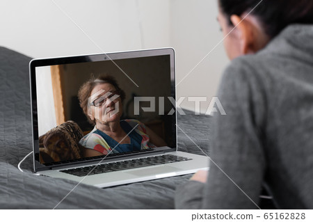 Young woman talking with elderly woman by video call at home. Remote medicine, nurse, tech 65162828